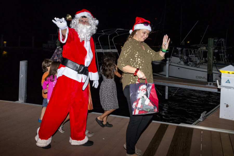 two people dressed as santa claus and mrs claus on a dock