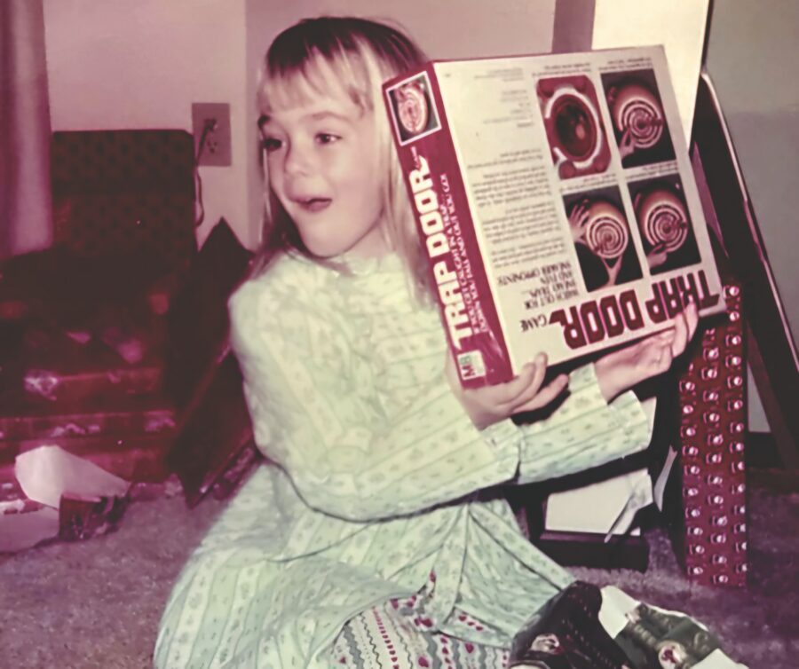 a little girl sitting on the floor holding a box