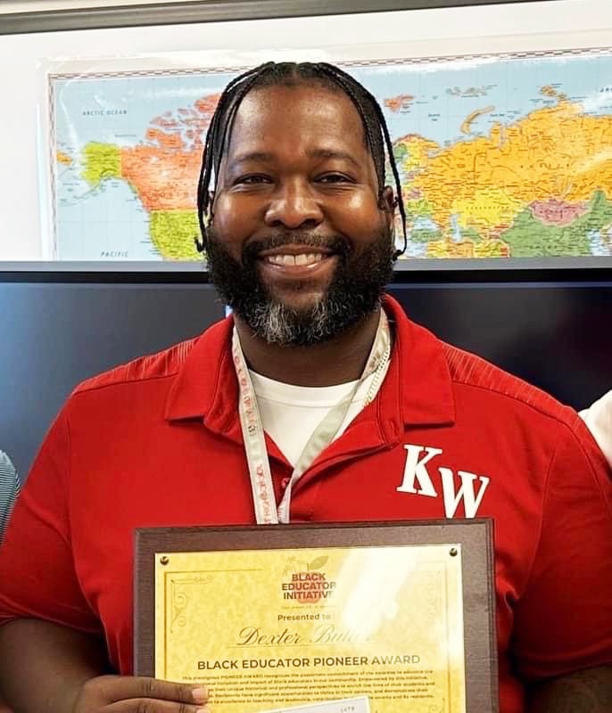 a man in a red shirt holding a plaque