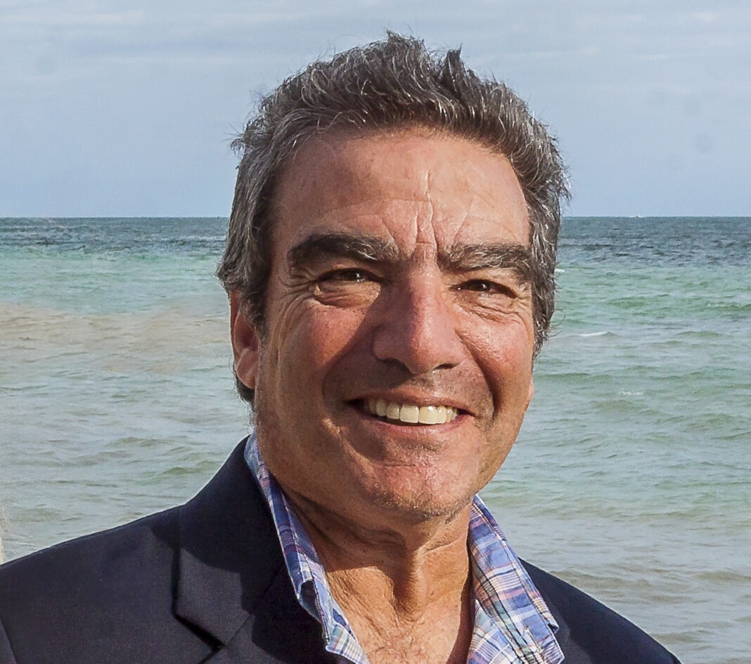 a man standing on a beach next to the ocean