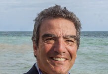 a man standing on a beach next to the ocean