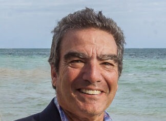 a man standing on a beach next to the ocean