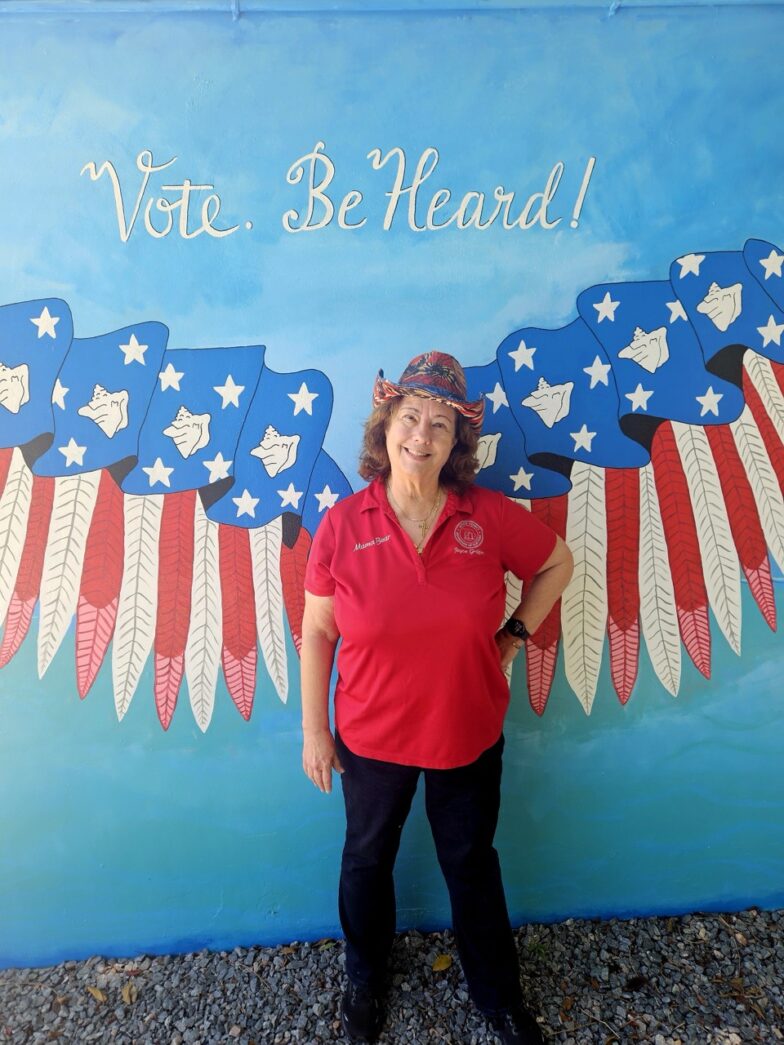 a woman standing in front of a mural of an eagle