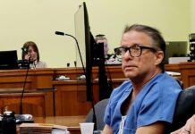 a man sitting at a table in a courtroom