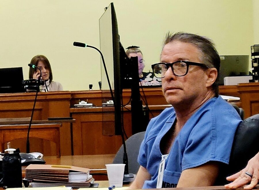 a man sitting at a table in a courtroom