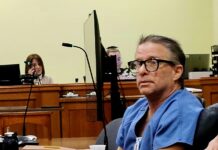 a man sitting at a table in a courtroom