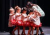 a group of young girls standing on top of a stage