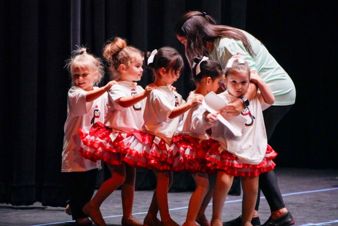 a group of young girls standing on top of a stage