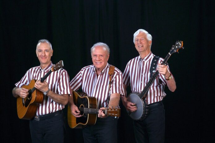 a group of men standing next to each other holding guitars