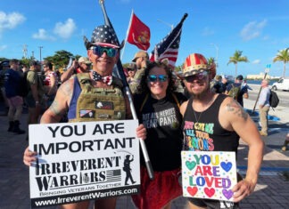 a group of people standing next to each other holding signs