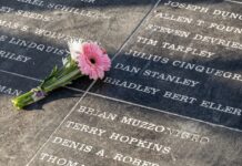 a pink flower is placed on a memorial