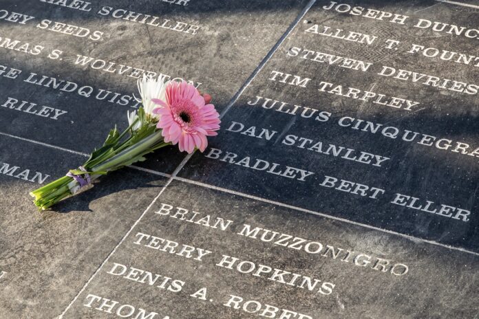 a pink flower is placed on a memorial