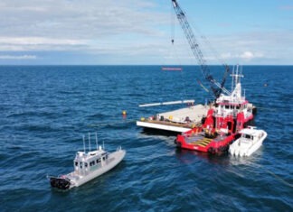 two boats in the water with a crane in the background