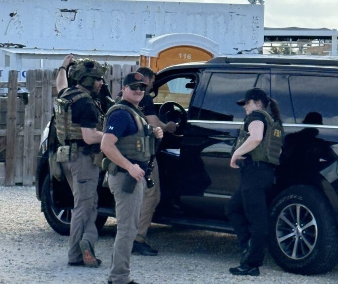 a group of men standing next to a black suv