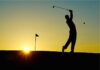 a silhouette of a person playing golf at sunset