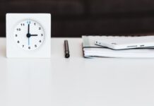 a white clock sitting on top of a white table