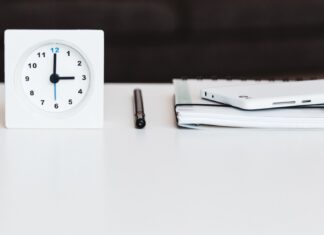 a white clock sitting on top of a white table