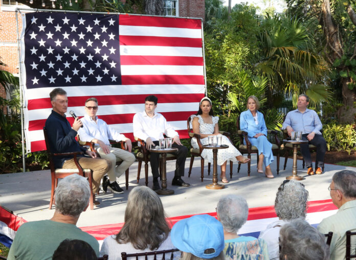 a group of people sitting in front of an american flag