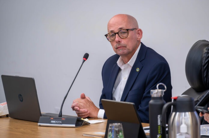 a man sitting at a table in front of a laptop computer