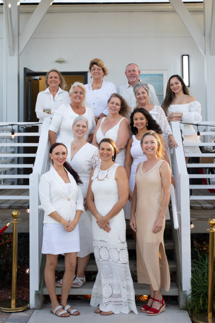 a group of women in white dresses standing in front of a building