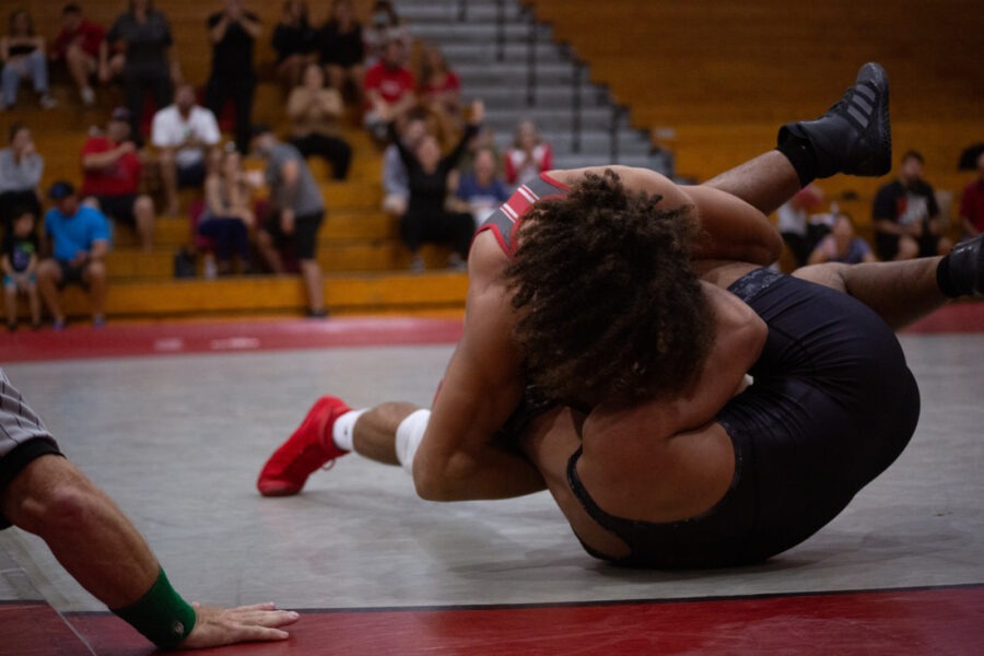 two wrestlers in a wrestling match with spectators in the background