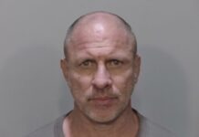 a mug shot of a man in a gray shirt