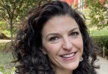 a woman with curly hair smiling at the camera