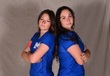 two women in blue shirts posing for a picture