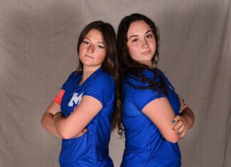 two women in blue shirts posing for a picture