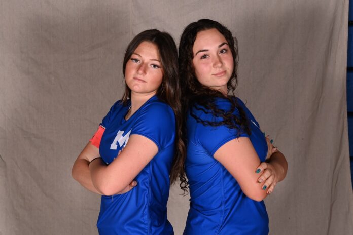 two women in blue shirts posing for a picture