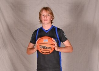 a young man holding a basketball in his hands