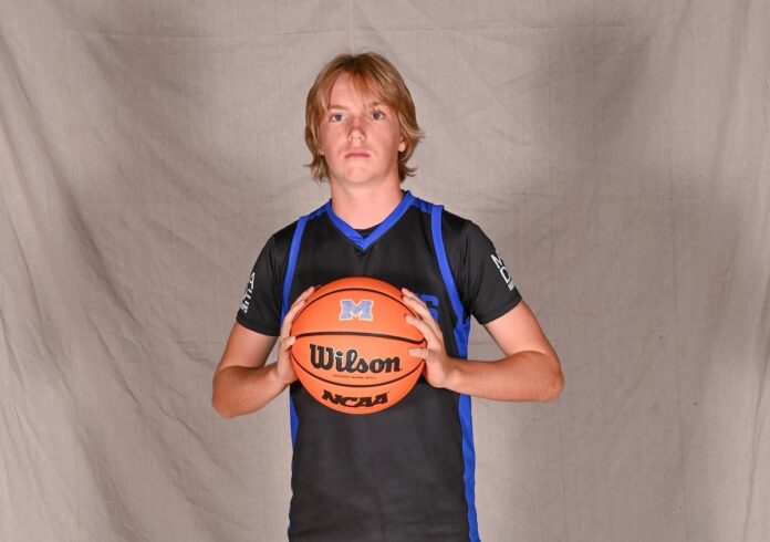 a young man holding a basketball in his hands