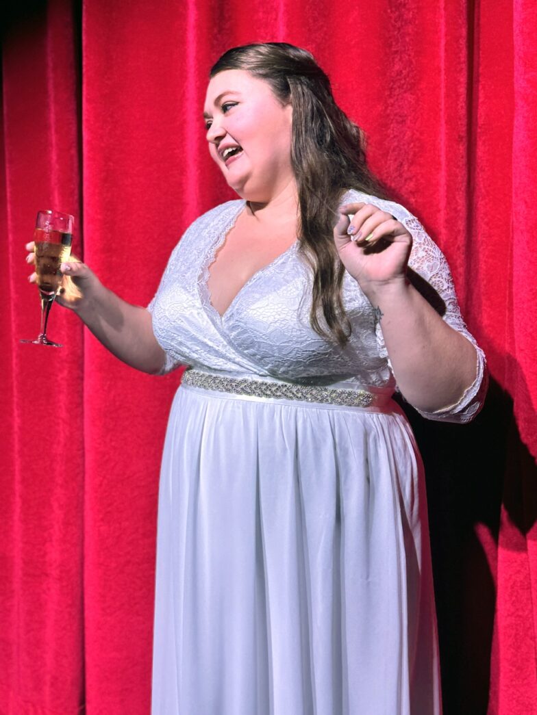 a woman in a white dress holding a glass of wine