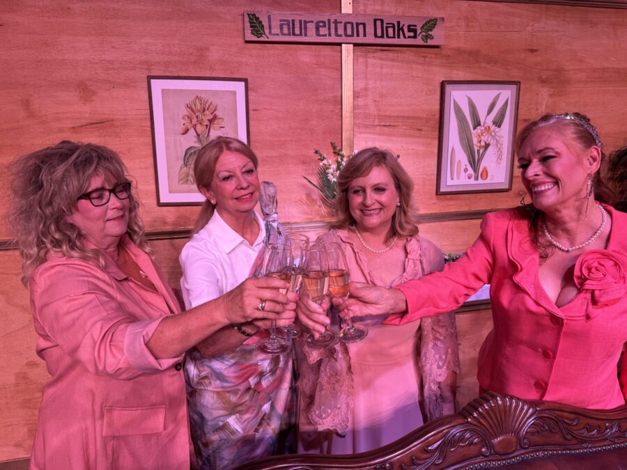 a group of women standing next to each other holding wine glasses