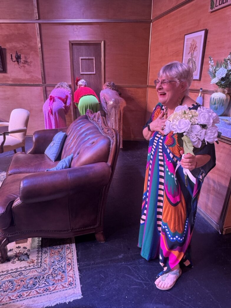 a woman standing in a living room holding a bouquet of flowers