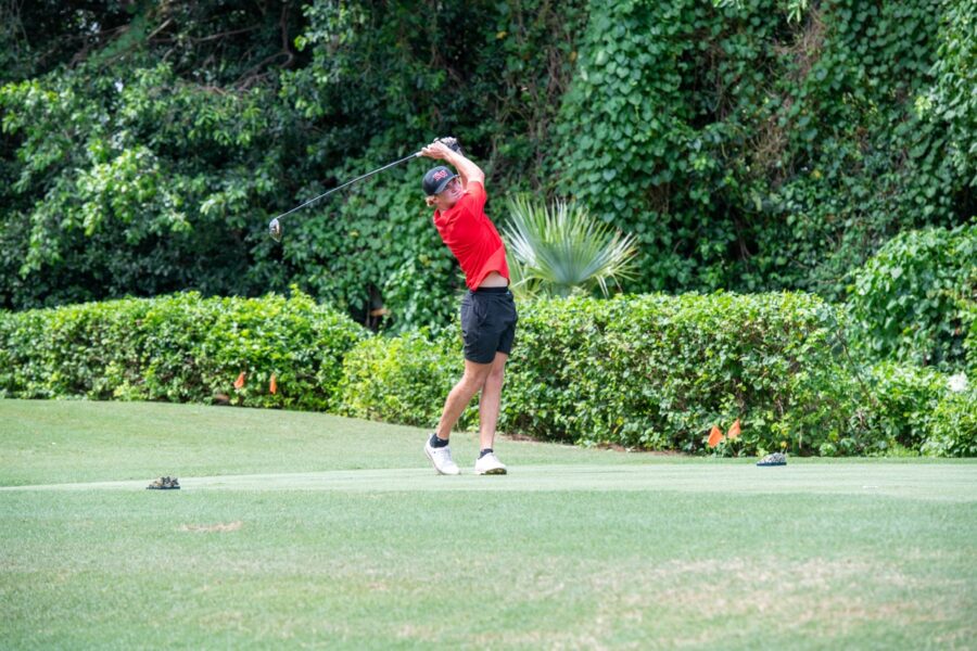 a man swinging a golf club on a golf course