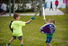 two young boys playing with a sword and shield