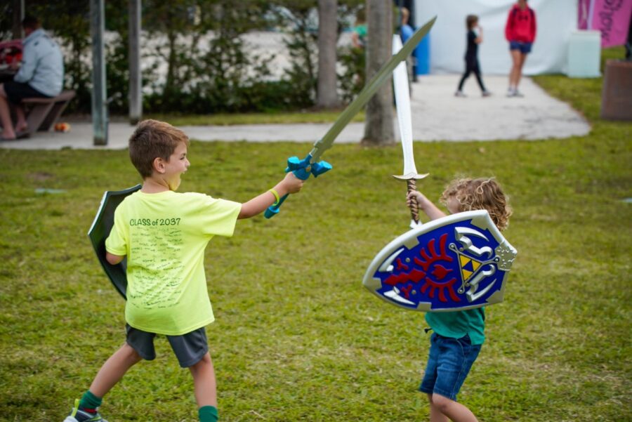 two young boys playing with a sword and shield