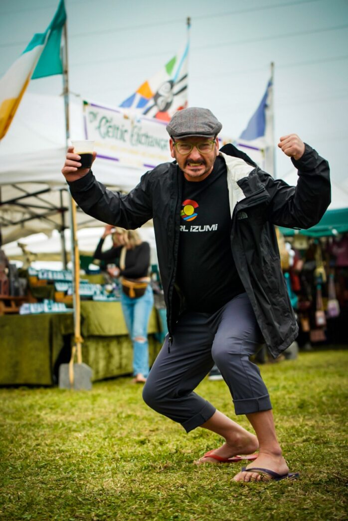 a man is dancing in the grass at a festival