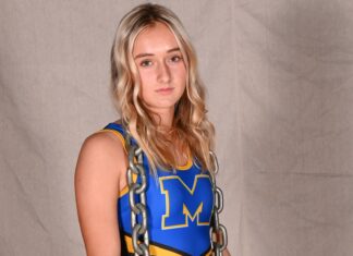 a woman in a blue and yellow uniform holding a chain