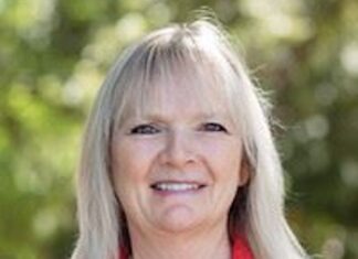 a woman in a red shirt is smiling