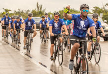 a group of men riding bikes down a street