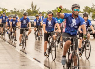 a group of men riding bikes down a street