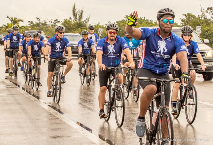 a group of men riding bikes down a street