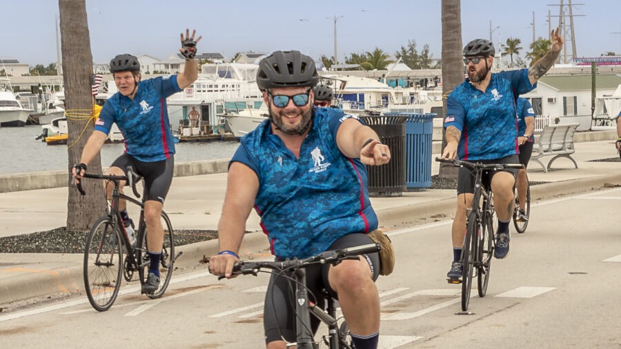 a group of men riding bikes down a street