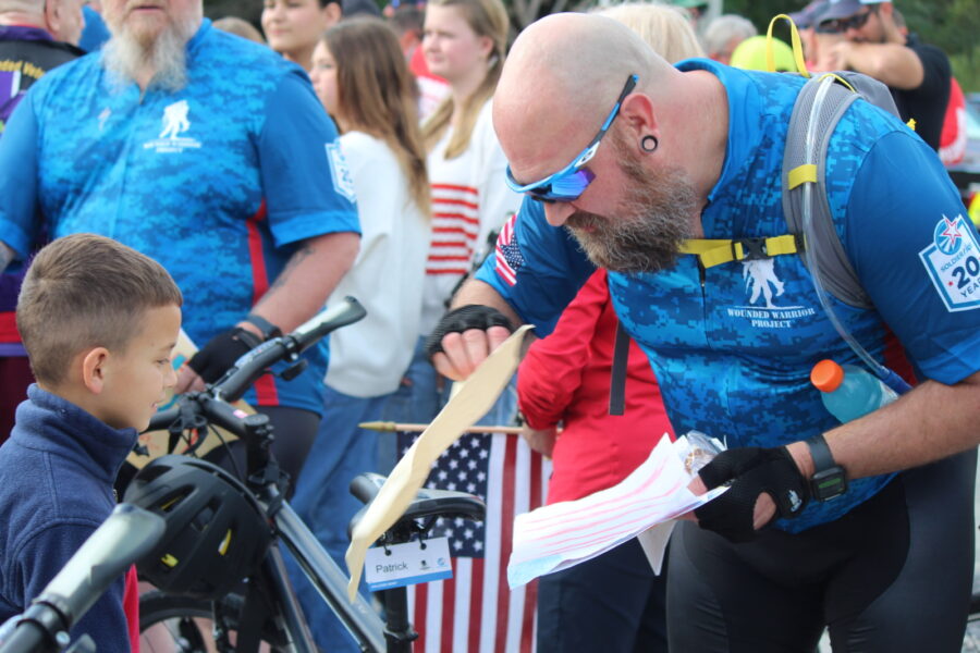 a man in a blue shirt is looking at a bike