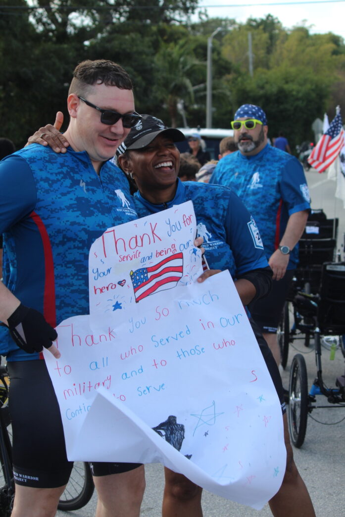 a group of men standing next to each other holding a sign