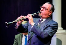 a man in a suit playing a flute