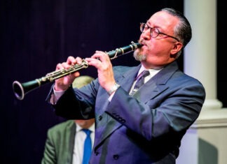 a man in a suit playing a flute