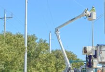 a couple of men working on a utility truck